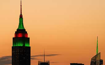 Empire State Building with red and green lights at dusk